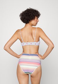 Sutiã com alças finas, azul claro com padrão floral; parte de baixo de cintura alta, listras pastel em rosa, roxo, verde e creme.