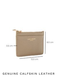 Kaarthouder van kalfsleer in beige, met een gouden rits en een geperst logo. Afmetingen: 12 cm breed, 8 cm hoog, 0,6 cm diep.