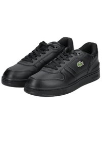 Black leather sneakers with a smooth finish, lace-up design, and a side logo. Features a rubber sole and slight textured accents.