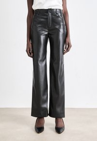 Black faux leather wide-leg pants with a high waist, featuring a front zip closure and smooth, glossy texture. Simple design and clean lines.