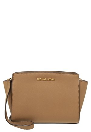 Beżowa bransoletka Michael Kors z złotym logo, teksturowanym wykończeniem i paskiem po lewej stronie.