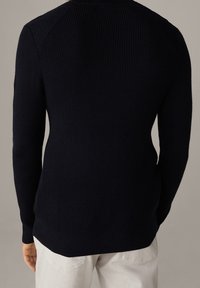 Maglione a coste blu navy con maniche lunghe e orlo arrotondato, caratterizzato da un design a maglia testurizzata e dettagli a contrasto sulle spalle.