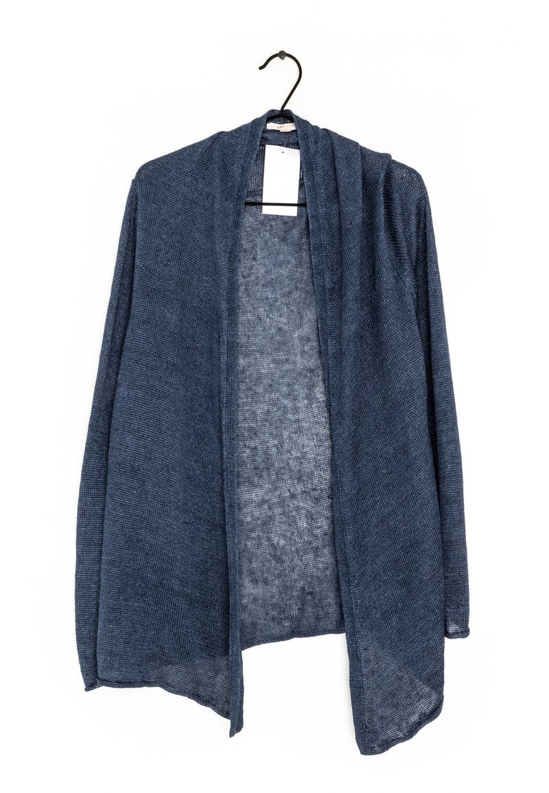 Stickad kofta i mörkblått, öppen framsida med ett lätt, strukturerat tyg. Långa ärmar med fållkant, hängande på en svart krok.