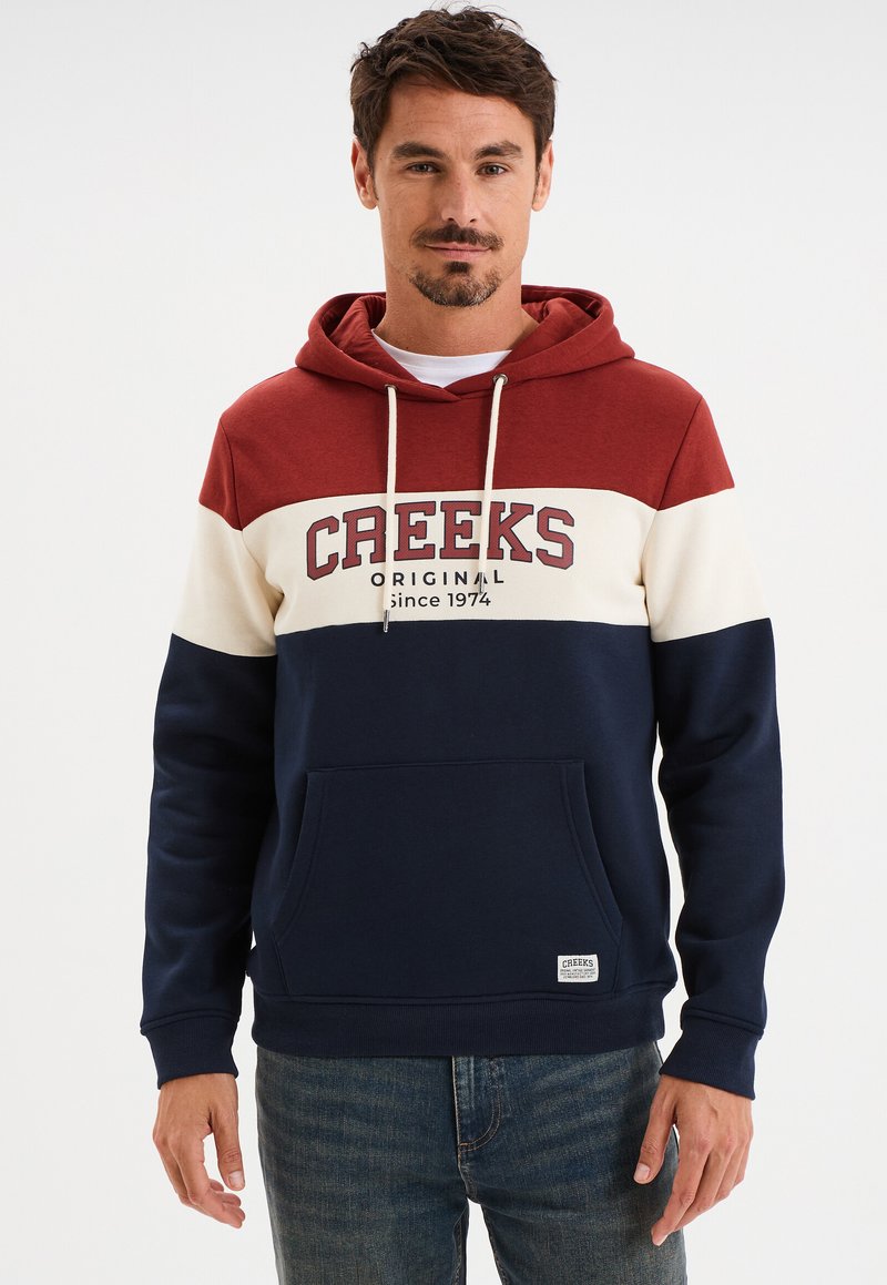 Sudadera con capucha en bloques de color rojo, crema y azul marino. Cuenta con un bolsillo frontal, cordón y el texto del logo de la marca en el pecho. Tejido de mezcla de algodón.