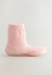 Różowa dziana skarpetka z miękkim, be seamowym cholewką i elastyczną, przezroczystą gumową podeszwą. Żebrowana tekstura na ściągaczu.