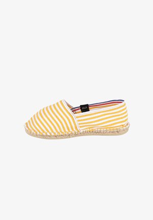 Espadrille rayée jaune et blanche avec semelle tissée et une étiquette noire portant l'inscription "Art of Soule" sur le côté.