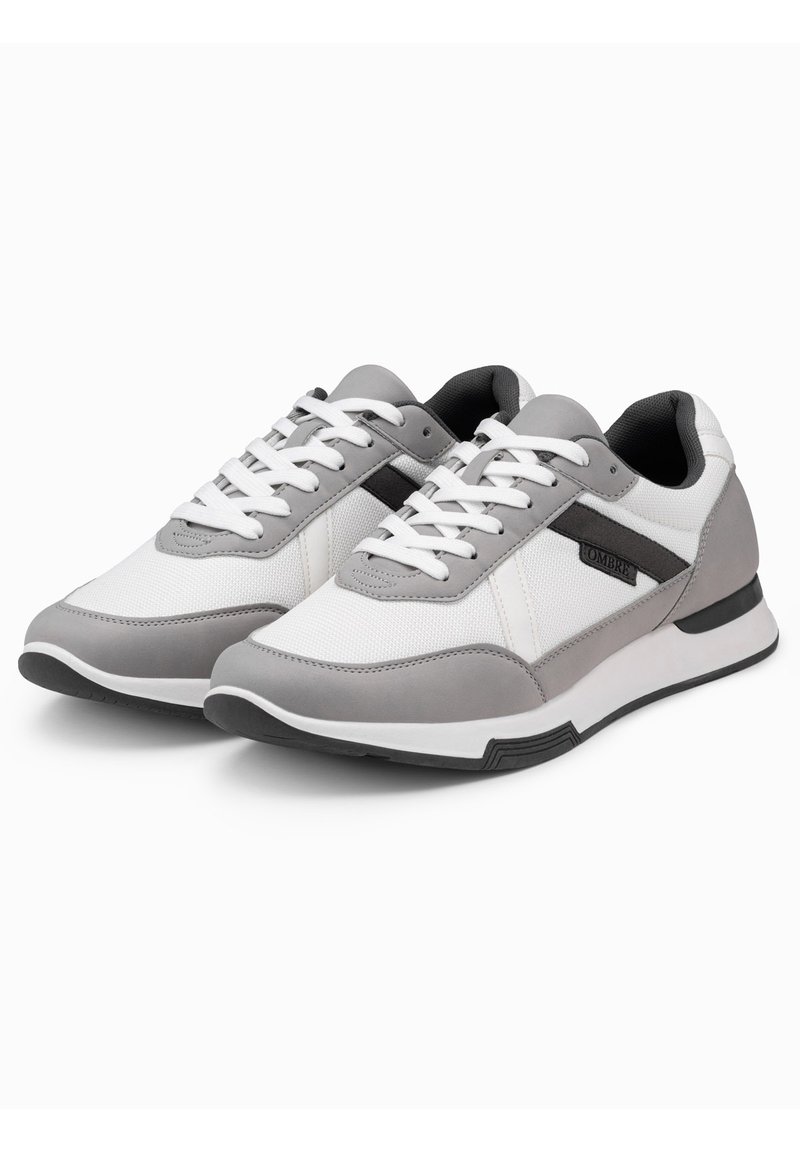 Pánské sportovní boty s bílým síťovaným svrškem, šedými syntetickými akcenty, bílými tkaničkami a černou gumovou podrážkou. Disponují elegantním designem a nižší hmotností.