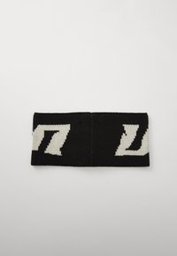Sorte strikkede pandebånd med hvide zigzag-mønstre. Blød tekstur, der måler cirka 24 cm i længden og 7 cm i bredden.