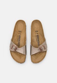 Bronse metalliske sandaler med en enkelt stropp og spenne. Sålen er formet, laget av brunt semsket materiale.