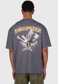 Gray cotton t-shirt featuring a large eagle graphic and mountains. Text reads "DROPSIZE" above, "365 HUNTING DAYS" on a banner below.
