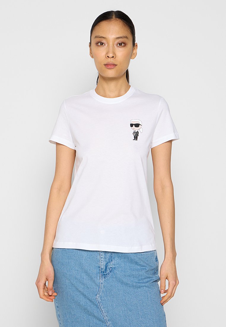 Tricou alb din bumbac cu o mică ilustrație grafică pe partea stângă a pieptului. Guler rotund și mâneci scurte, croială standard.