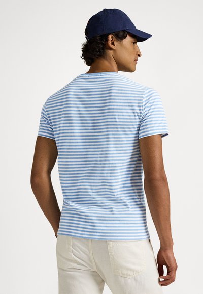 Ριγέ κοντομάνικο μπλουζάκι σε ανοιχτό μπλε και άσπρο, εφαρμοστή γραμμή, κατασκευασμένο από απαλό βαμβάκι, με στρογγυλή λαιμόκοψη και διακριτική λεπτομέρεια πλαϊνής ραφής.