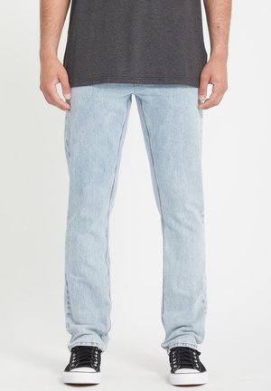 Light blue denim jeans with a straight-leg fit, faded texture, and classic five-pocket design. Paired with black sneakers.