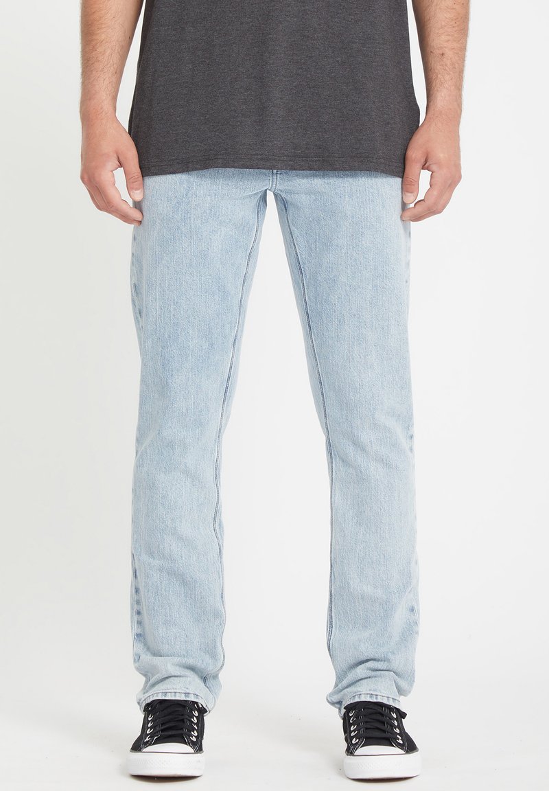 Lichtblauwe denim jeans met een recht gesneden pasvorm, vervaagde textuur en een klassiek vijf-pocketontwerp. Gepaard met zwarte sneakers.