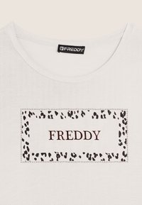 T-shirt bianca con scollatura ampia, caratterizzata da un bordo rettangolare in stampa leopardata e il nome del marchio "FREDDY" in testo marrone scuro.