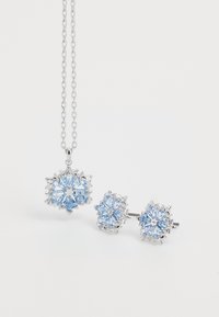Silbernes Schmuckset mit einer Halskette, die mit einem Schneeflocken-Anhänger versehen ist, und passenden Ohrringen, die beide mit hellblauen Steinen verziert sind.
