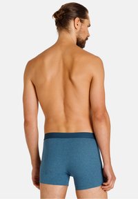 Heren blauwe boxershorts van een gestructureerde stof, met een contrasterende donkere tailleband en een slim fit ontwerp, zichtbaar vanuit de achterkant.