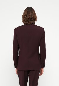 Maroon suit jacket viewed from the back, featuring a notched lapel and two black buttons on each sleeve. Tailored fit with smooth texture.