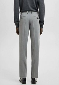 Szare, dopasowane spodnie garniturowe o wąskim kroju, z dwoma tylnymi kieszeniami zapinanymi na guziki, prostymi nogawkami i gładką fakturą tkaniny.