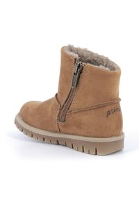 Stivale alla caviglia in suede color tan con chiusura a zip sul lato, rivestito in pelliccia sintetica, e suola in gomma. Presenta un piccolo logo ricamato sul retro.