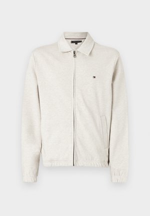 Lysegrå lynlåssweatshirt med spids krave, lange ærmer og sidelommer. Har en lille logo på brystet. Glat tekstur.