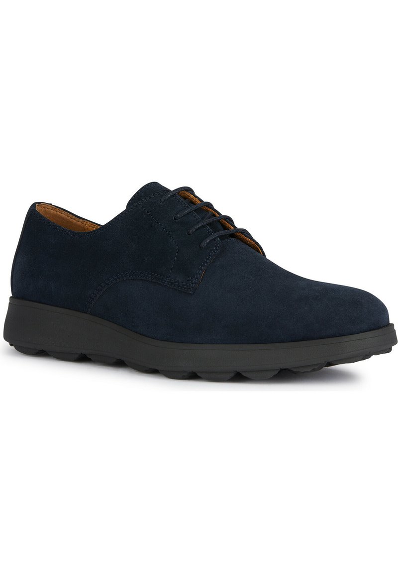 Chaussures en suede navy à lacets avec un bout arrondi et une semelle en caoutchouc noir, présentant des détails de couture subtils et un intérieur en cuir marron.