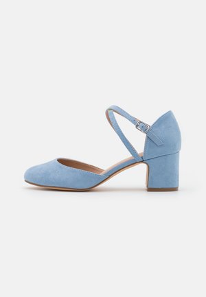 Chaussure bleu clair en daim avec petit talon bloc, bout fermé et bride de cheville ajustable avec boucle argentée, vue de côté.