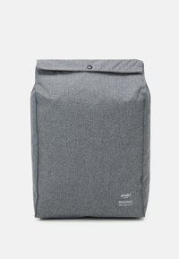 Šedý látkový batoh s rolovací uzávěrkou, vybavený patentním knoflíkem a logem v dolním rohu, hladká textura a obdélníkový tvar.