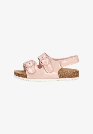 Sandalias rosas con purpurina, dos correas ajustables, hebillas en forma de corazón, plantilla de corcho y suela de goma blanca. Diseño ligero y abierto.