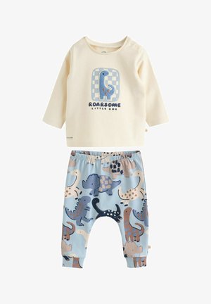 Compleu pentru copii format din două piese: bluză crem cu mânecă lungă și grafică cu dinozaur, asociată cu pantaloni bleu deschis cu imprimeu multicolor cu dinozauri.