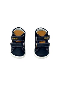 Scarpe in pelle nera per bambini con doppie fasce in Velcro, cuciture bianche e una suola in gomma chiara. Visibile il marchio dorato "Primigi".