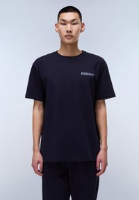 Marineblå bomulds t-shirt med korte ærmer, rund hals og lille mærke-graphic på brystet. Lige pasform, glat tekstur.