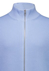 Giacca azzurra chiaro a coste con zip e collo alto, caratterizzata da una zip argentata e tessuto strutturato, che offre una silhouette aderente.