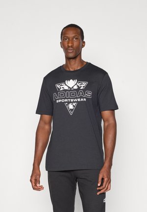 Tricou negru cu un logo Adidas alb mare și un design floral pe față, cu un guler rotund clasic și mâneci scurte.