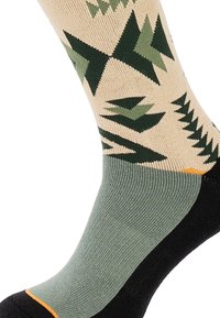 Ponožky po kolená, s béžovým základným farebným prevedením a zelenými geometrickými vzormi stromov, tmavozelený podpätok a čierna špička s oranžovým akcentom.