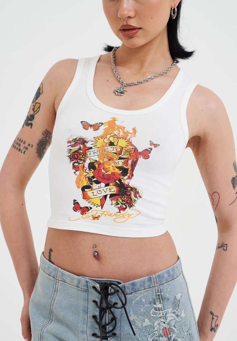White cropped tank top featuring a colorful graphic with roses, butterflies, flames, and the text "TRUE TO MY LOVE" in bold lettering.