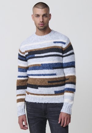 Suéter de punto con rayas horizontales en azul, marrón y negro sobre un fondo claro, con cuello redondo y puños acanalados.