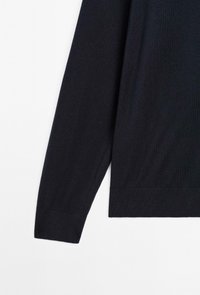 Long black knitted sweater sleeve with ribbed cuff and hem on a white background.
