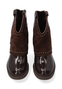 Para ciemnoniebieskich skórzanych i zamszowych botków za kostkę z dekoracyjnymi srebrnymi ćwiekami i okrągłymi noskami na białym tle.