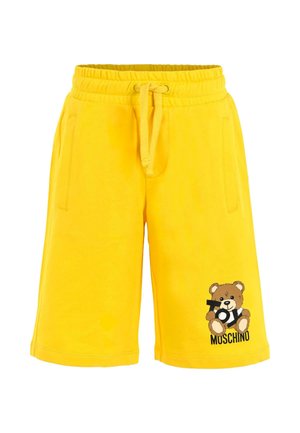 Pantaloni corti gialli con vita elasticizzata e cordoncino, tasche frontali e un orsetto che tiene in mano "Toy" con il testo "Moschino" sulla gamba.
