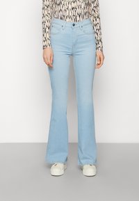 Light blue flared jeans made of denim, featuring a high waist, five pockets, and a classic button closure. The fabric has a smooth texture.