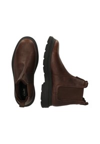 Bruine leren Chelsea-boots met elastische zijkanten, textuur bovenwerk en rubberen zool, met een aantrektab aan de hiel voor gemakkelijke aan- en uittrekking.