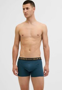 Zöldeszöld boxeralsó fekete derékkal, rajta sárga márkanevével: "JACK & JONES". Simább textúra, testhezálló dizájn és combközép hosszúság.