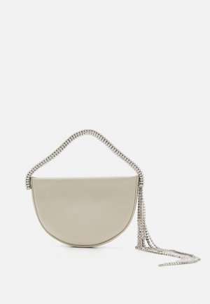 Sac en bandoulière beige en forme de demi-lune, avec une texture lisse et une chaîne à accent en cristal qui tombe sur le côté, ajoutant un intérêt visuel.