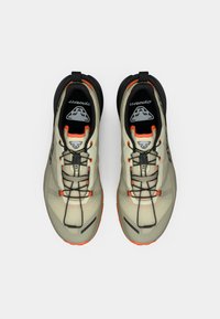 Ελαφριά μπεζ αθλητικά παπούτσια τρεξίματος με μαύρες λεπτομέρειες και πορτοκαλί στοιχεία; διχτυωτό πάνω μέρος, υφή σχεδίασης και flexibλό πέλμα με μοτίβο πρόσφυσης.