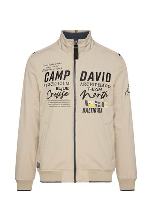 Giacca beige con zip, caratterizzata da un colletto alto, testo stampato, due tasche laterali e polsini e orlo a coste. Texture liscia e design leggero.