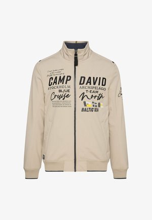 Beige zip-up jack met een staande kraag, bedrukte tekst, twee zijzakken en ribgebreide manchetten en zoom. Smooth textuur en lichtgewicht ontwerp.