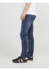 Slim-fit blå denimjeans med en subtil tvätt, som har traditionell femficksdesign och kontrasterande sömmar. Bärs med svarta sneakers.