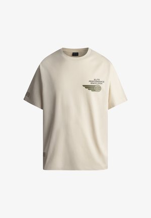 Beidzīgi kokvilnas T-krekls ar brīvu piegriezumu, ar zaļu grafisku druku uz krūšu daļas un izšūtu logotipu uz kreisā piedurknes.