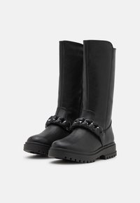 Bottes noires en cuir montantes jusqu'aux genoux avec une finition mate, dotées d'un accent décoratif de chaîne et d'une semelle robuste pour une meilleure traction.